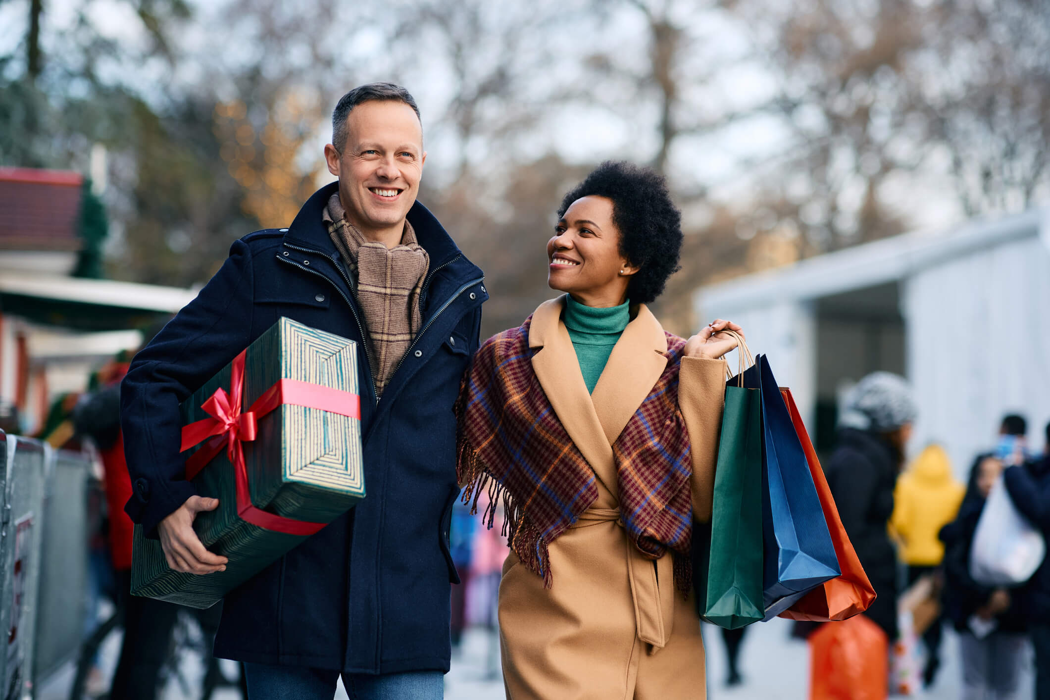 Happy man and his wife with holiday presents walking through the city of Milford, CT