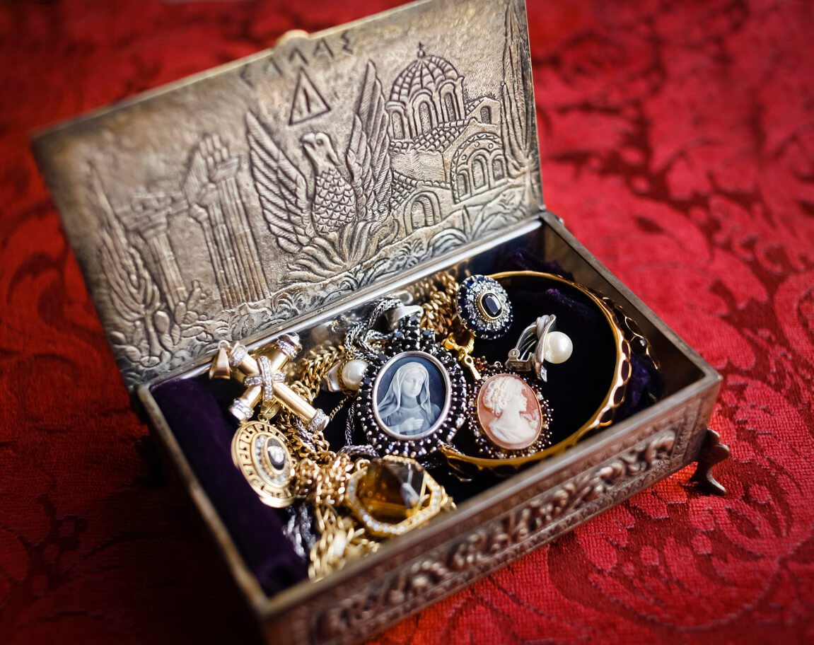 Metal Box Filled with Trinkets atop Red Table