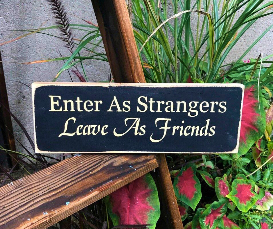 sign that says enter as strangers, leave as friends.